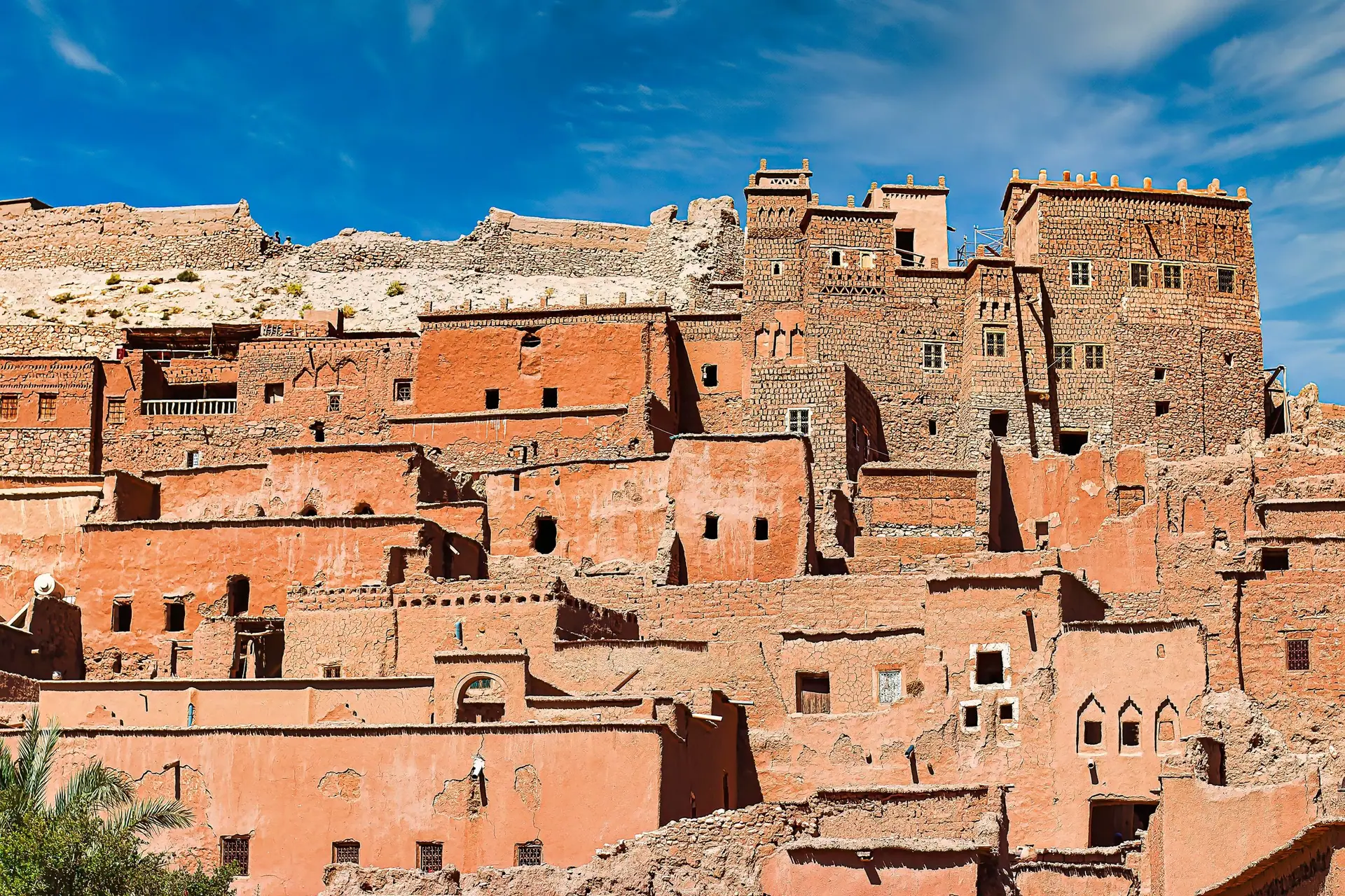 Capture of the ancient Ait Benhaddou Kasbah in Morocco with its distinctive earthen clay architecture against a clear blue sky.