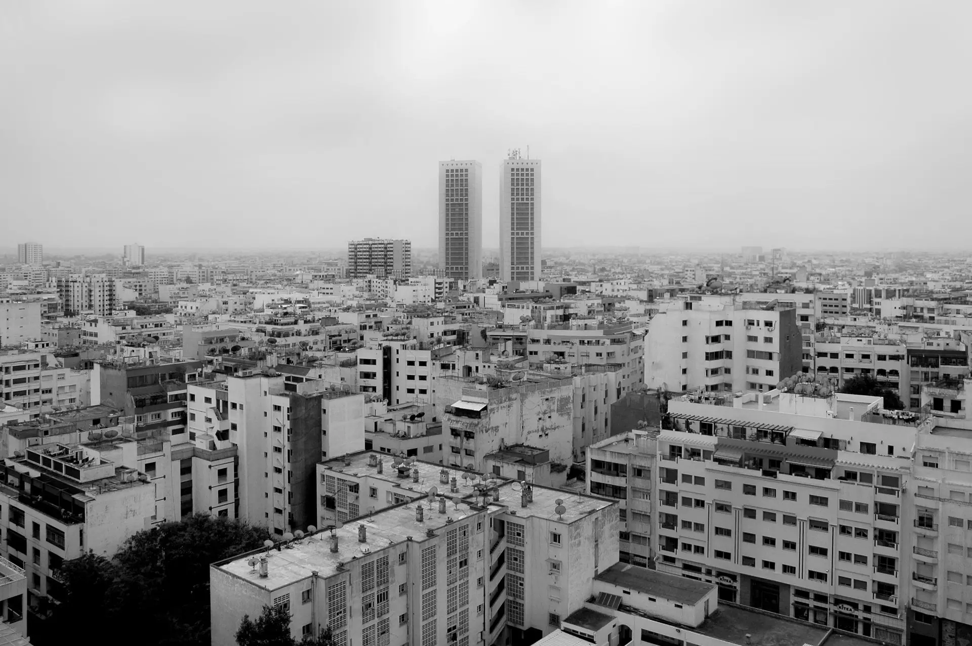 A dramatic black and white aerial view of Casablanca's cityscape with iconic skyscrapers.