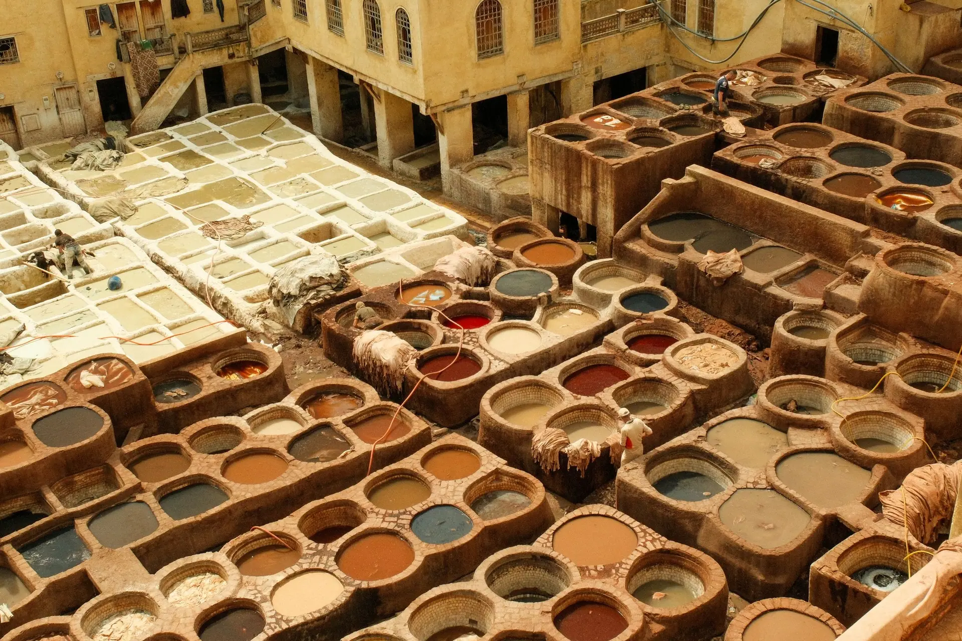 Aerial view of colorful vats at a traditional leather tannery in Fes, Morocco.