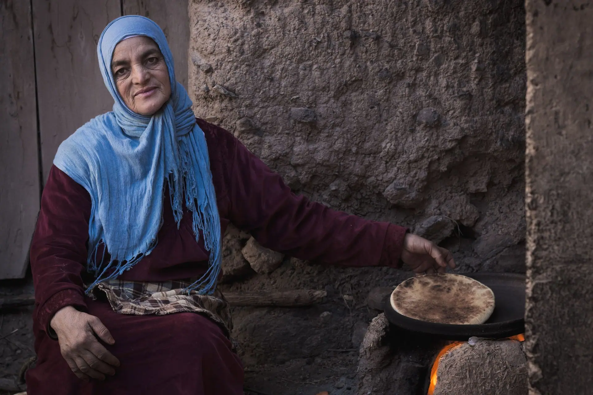 Traditional Moroccan woman baking flatbread in Ourika, Morocco.